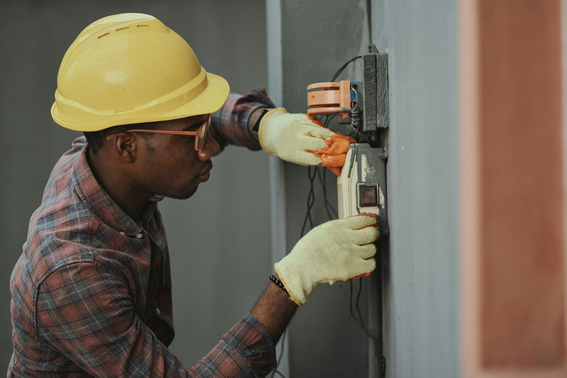 An electrician wiring a switchboard on a job site